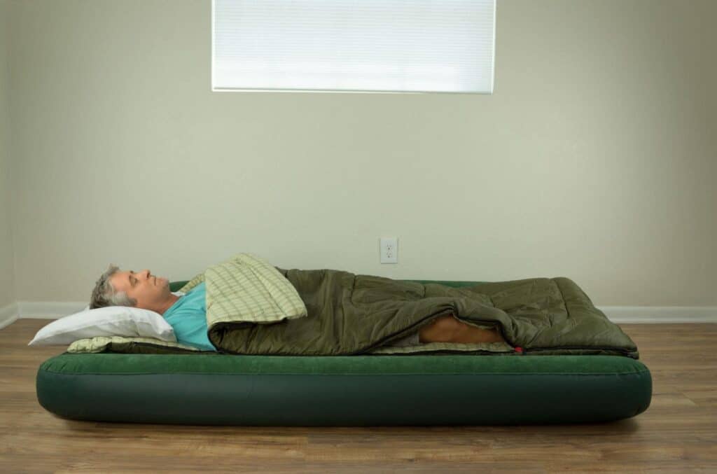 A Man Sleeping on the Floor With Mattress