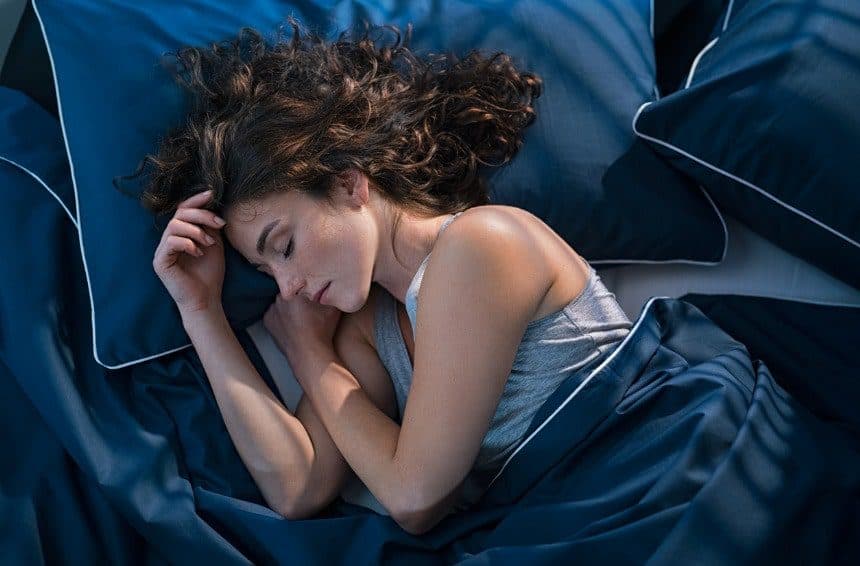 A young girl sleeping on a bed at night