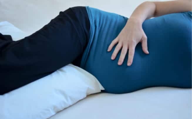 A Pregnant Woman Is Sleeping With Pillow Between the Legs